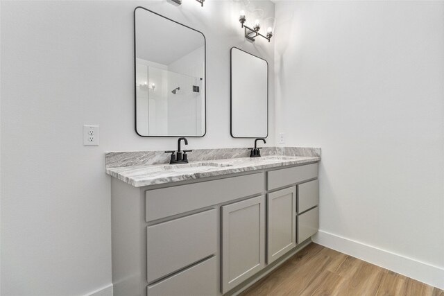 bathroom with vanity, a shower, and hardwood / wood-style flooring