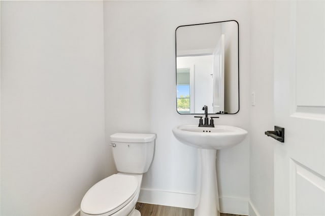 bathroom featuring wood-type flooring and toilet