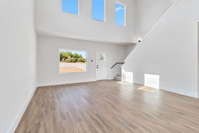 entrance foyer featuring light hardwood / wood-style flooring and a high ceiling