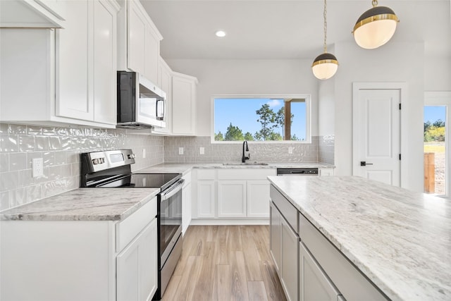 kitchen featuring stainless steel appliances, sink, plenty of natural light, and white cabinets