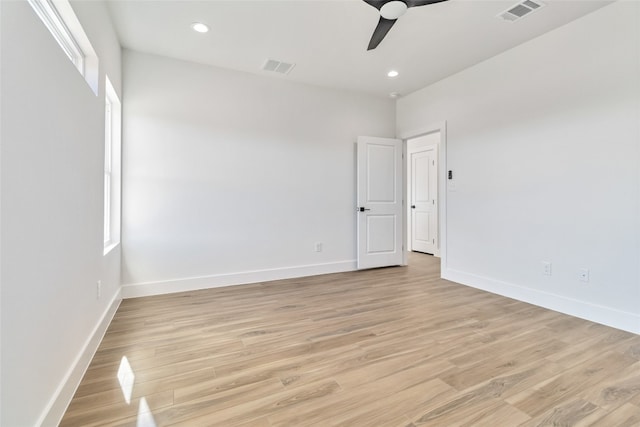 empty room featuring a healthy amount of sunlight, light wood-type flooring, and ceiling fan