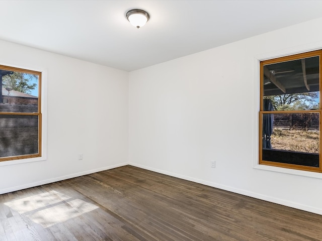 unfurnished room with dark hardwood / wood-style flooring