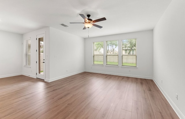 spare room featuring visible vents, light wood-style flooring, ceiling fan, and baseboards