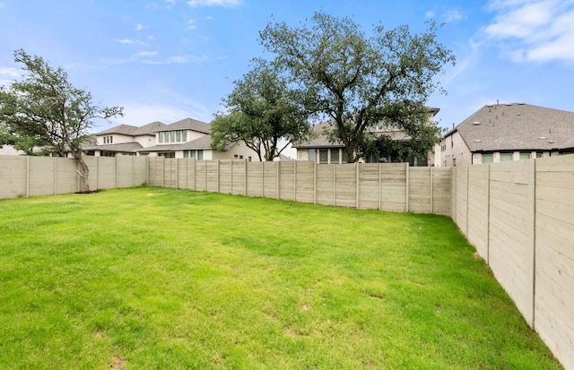 view of yard with a fenced backyard and a residential view