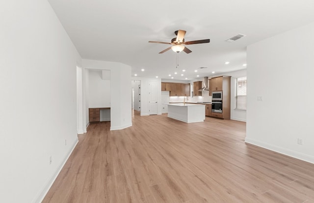 unfurnished living room featuring ceiling fan, visible vents, light wood-type flooring, baseboards, and recessed lighting