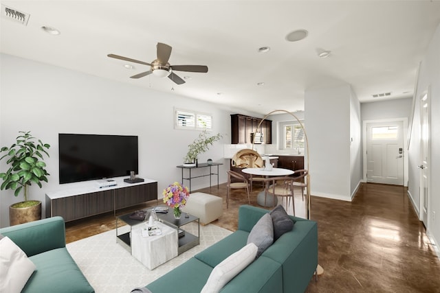 living room with concrete flooring and ceiling fan