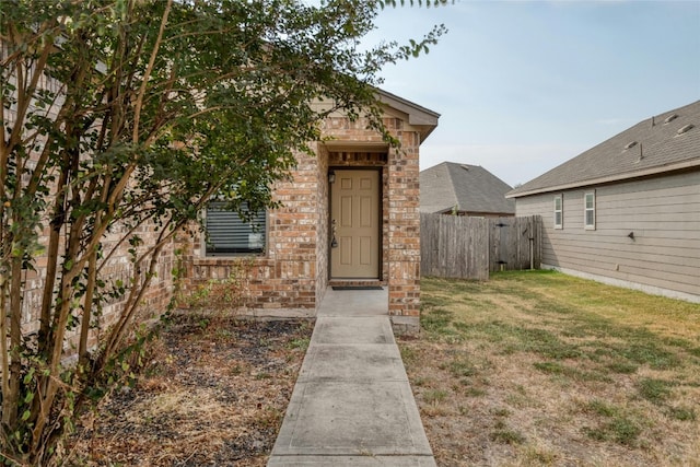 view of exterior entry featuring a yard