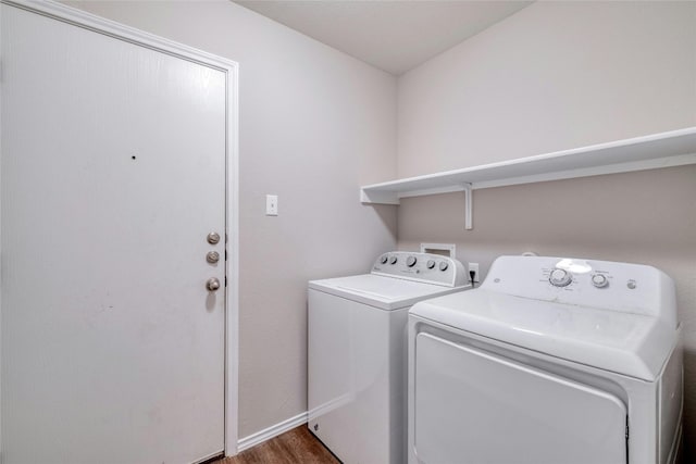 clothes washing area with independent washer and dryer and dark wood-type flooring