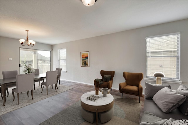 living room featuring wood-type flooring and an inviting chandelier