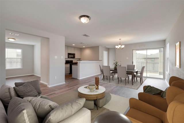 living room with light hardwood / wood-style flooring and a chandelier