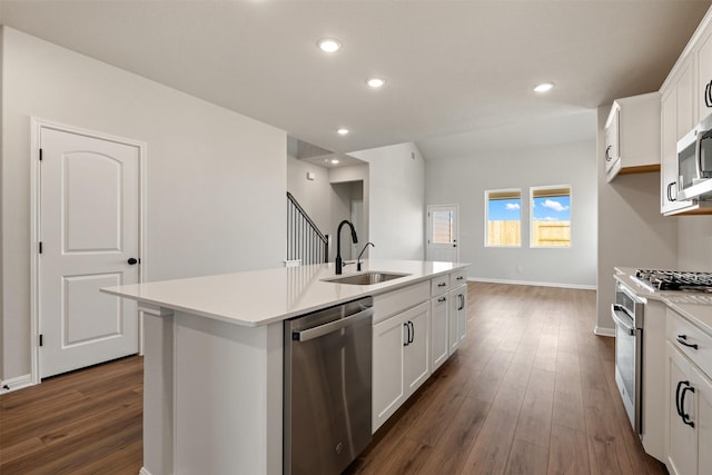 kitchen featuring white cabinetry, sink, stainless steel dishwasher, a center island with sink, and range