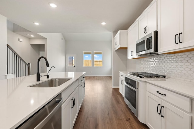 kitchen featuring tasteful backsplash, white cabinetry, sink, and appliances with stainless steel finishes