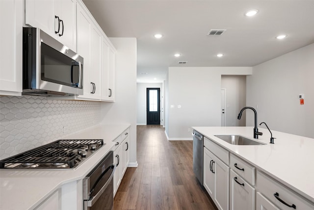 kitchen with stainless steel appliances, white cabinetry, and sink