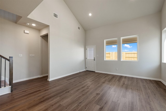 empty room with dark hardwood / wood-style floors and high vaulted ceiling