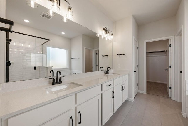 bathroom with tile patterned floors, vanity, and a shower with door