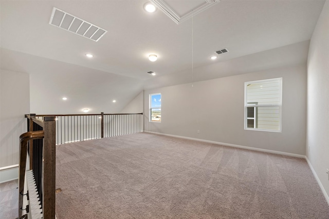 carpeted spare room with lofted ceiling