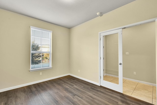 spare room with french doors and hardwood / wood-style flooring