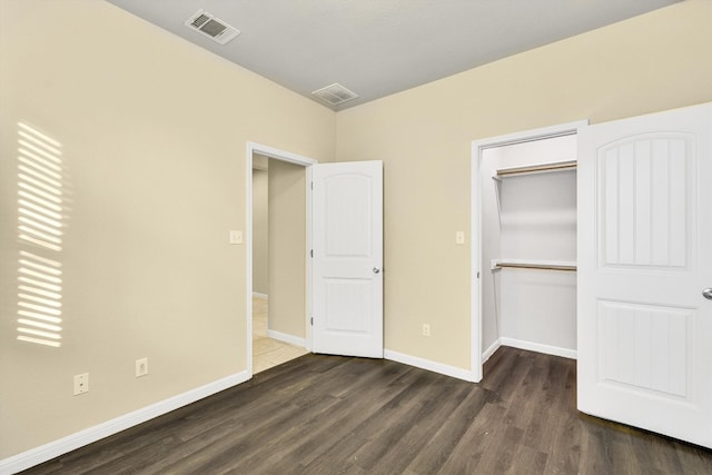 unfurnished bedroom with a closet and dark hardwood / wood-style flooring