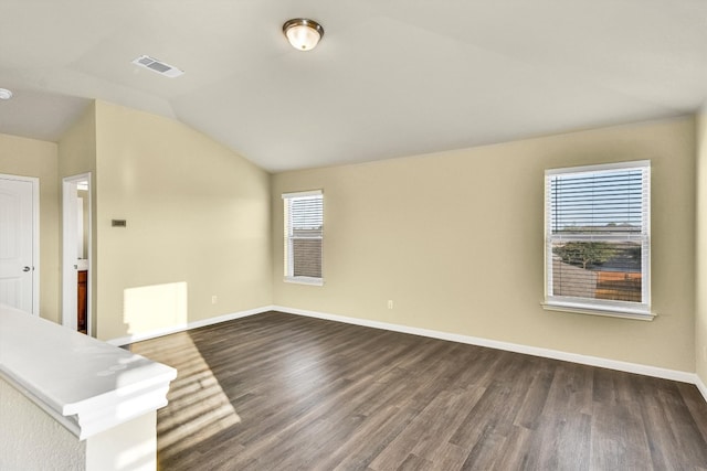 spare room featuring lofted ceiling and dark hardwood / wood-style flooring