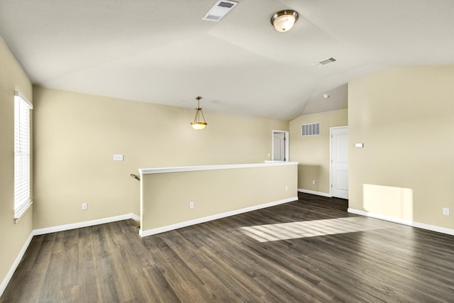 unfurnished room featuring dark wood-type flooring, vaulted ceiling, and a wealth of natural light