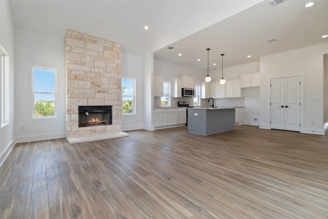 unfurnished living room featuring hardwood / wood-style floors, sink, and a fireplace