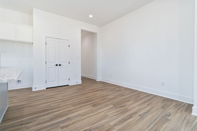 unfurnished bedroom featuring hardwood / wood-style floors and a closet