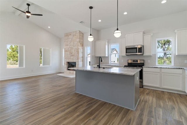 kitchen featuring sink, appliances with stainless steel finishes, a kitchen island with sink, and white cabinets