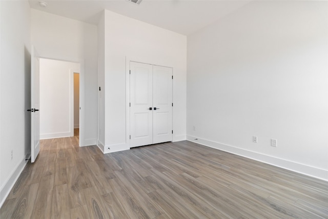 unfurnished bedroom featuring a closet and light wood-type flooring