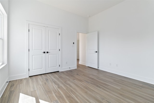 unfurnished bedroom featuring a closet and light hardwood / wood-style flooring