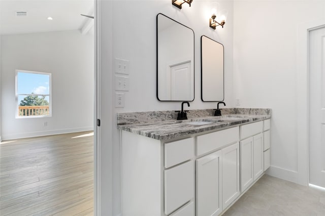 bathroom with vanity, lofted ceiling, and hardwood / wood-style flooring