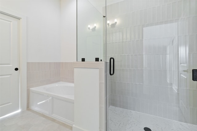 bathroom with tile walls, independent shower and bath, and tile patterned flooring