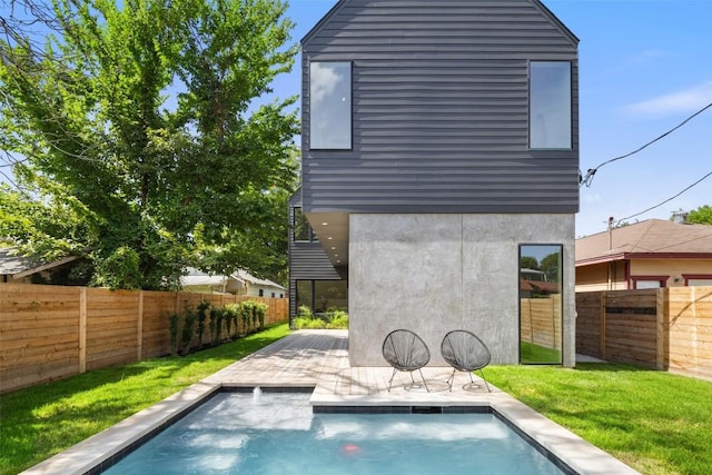 back of property featuring a fenced in pool, a lawn, and a patio