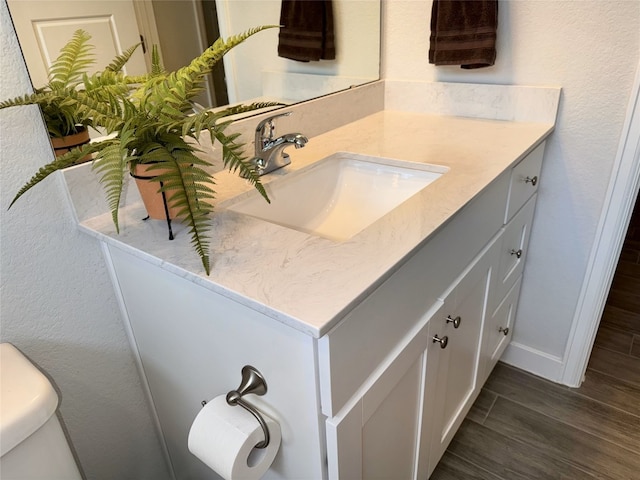 bathroom featuring vanity, toilet, and hardwood / wood-style floors