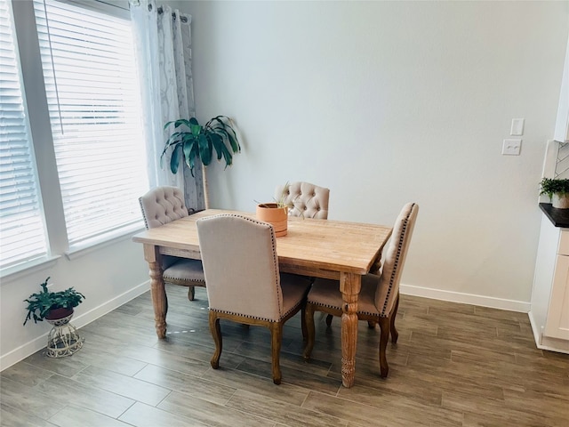 dining area featuring dark wood-type flooring and a healthy amount of sunlight