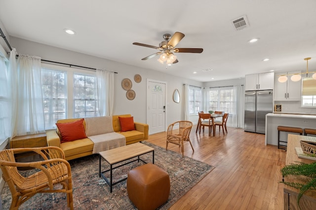 living room with ceiling fan and light hardwood / wood-style floors