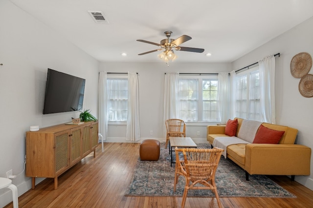 living room featuring ceiling fan and hardwood / wood-style flooring