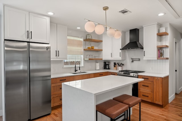 kitchen with white cabinets, sink, wall chimney exhaust hood, and appliances with stainless steel finishes