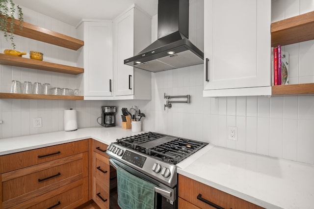 kitchen with white cabinetry, gas range, decorative backsplash, and wall chimney exhaust hood