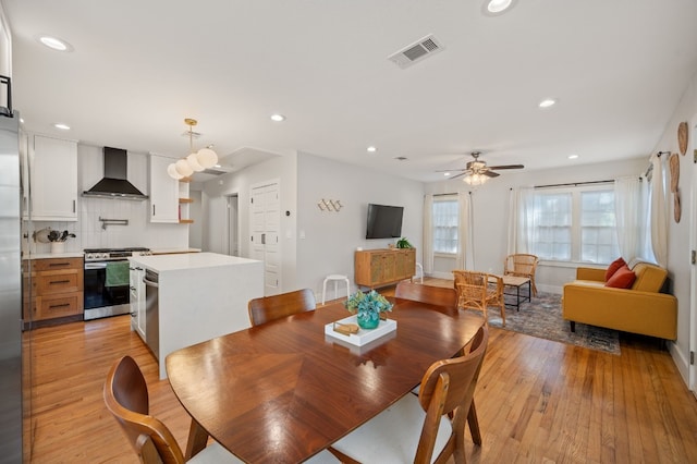 dining room with light hardwood / wood-style flooring and ceiling fan