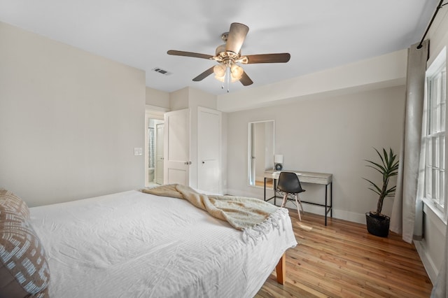 bedroom featuring multiple windows, light hardwood / wood-style floors, and ceiling fan