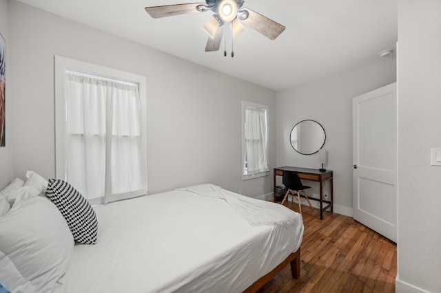 bedroom with multiple windows, wood-type flooring, and ceiling fan