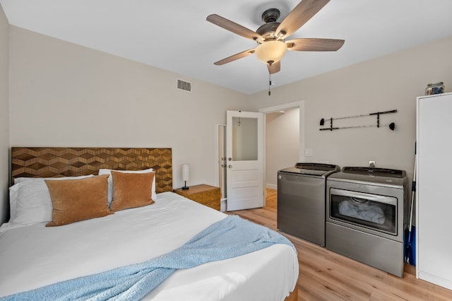 bedroom featuring washing machine and dryer, light hardwood / wood-style flooring, and ceiling fan