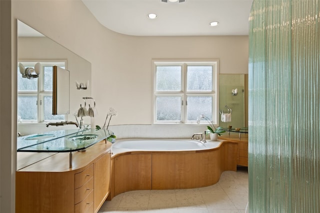 bathroom with vanity, tile patterned floors, and a washtub