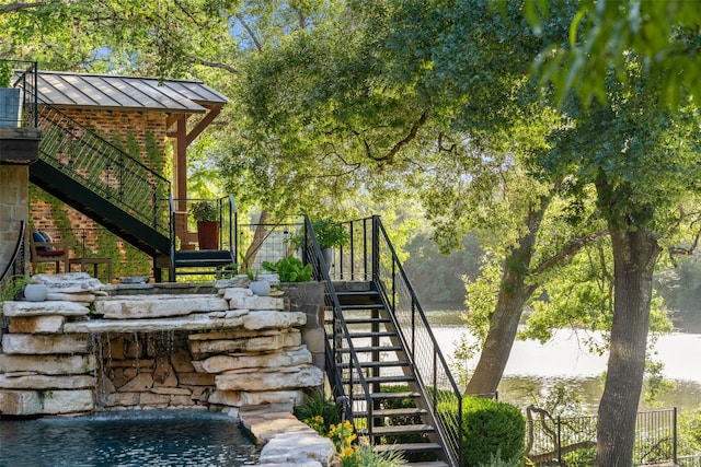 exterior space with a water view and pool water feature