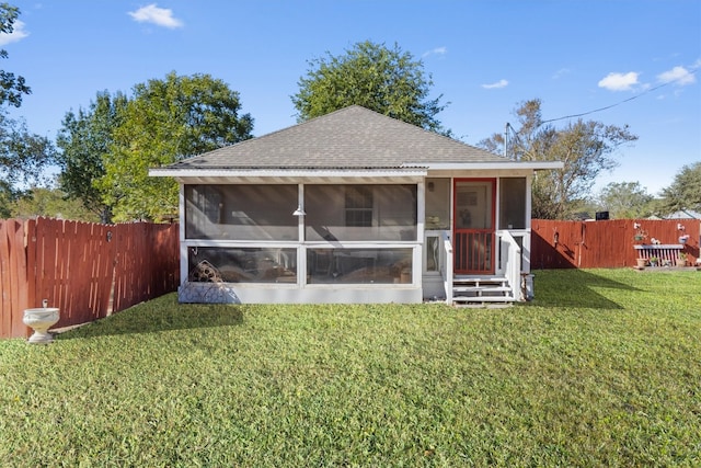 back of property featuring a sunroom and a lawn