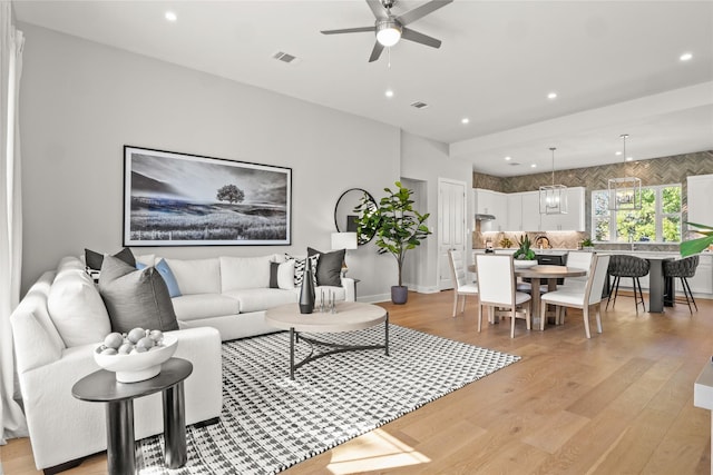 living room with ceiling fan and light hardwood / wood-style floors