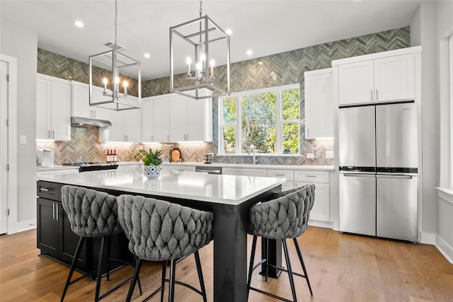 kitchen with a kitchen island, white cabinets, and appliances with stainless steel finishes