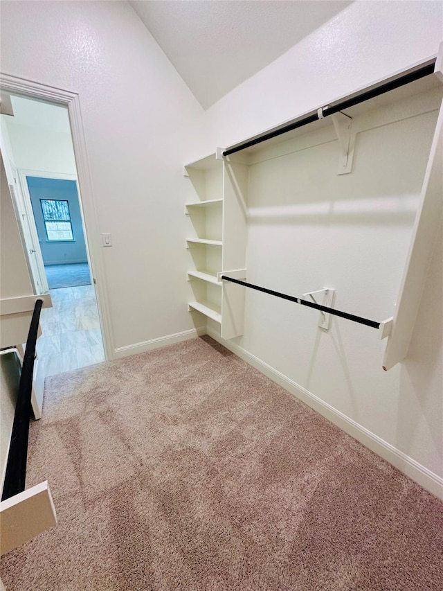 walk in closet featuring lofted ceiling and carpet flooring