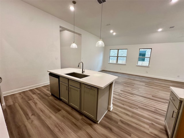 kitchen featuring dark hardwood / wood-style floors, dishwasher, an island with sink, sink, and hanging light fixtures