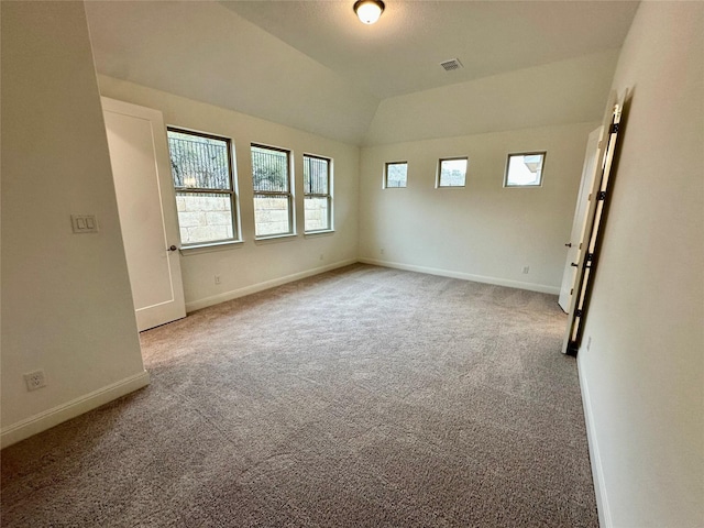 unfurnished room featuring lofted ceiling and carpet floors